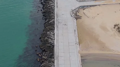 Drone view of coastal pier structure and sandy shoreline from above Stock Footage 322537925
