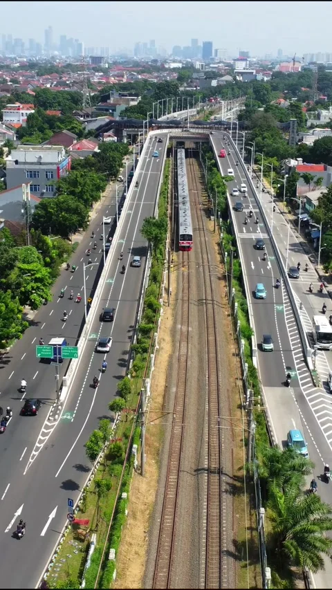 Drone view of a commuter train passing under an overpass 스톡 동영상 324180645