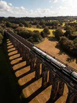 Drone view of commuter train passing over Ouse Valley Viaduct Stock Photos