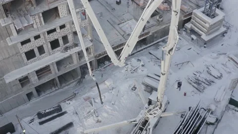 A drone view of the construction of a residential building using a concrete pump Stock Footage 202912737