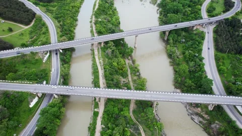 Drone view of contemporary bridge intersection above river Stock Footage 240739300