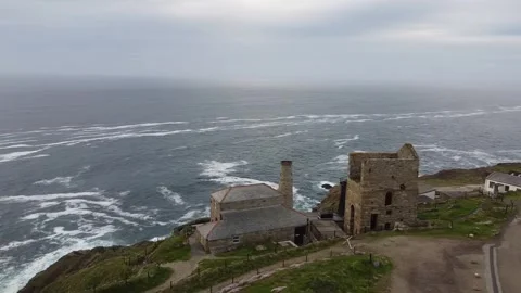 Drone view of Cornwall coastline with old industrial building and waves Видео 345967283