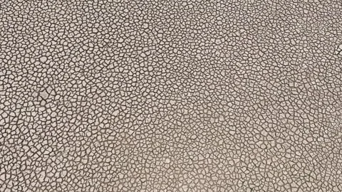 Drone view of cracked soil showing severe drought impact. Video stock 274375342