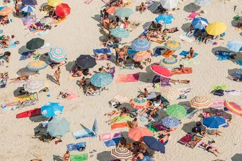 Drone view of crowd beach with white sand and colorful umbrellas top view. Stock Photos