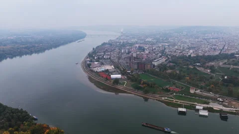 A drone view of the Danube bending past Belgrade as a barge moves downstream 스톡 동영상 324900948
