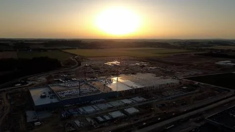 Drone view of a data center construction site silhouetted against a sunset Stock Photos