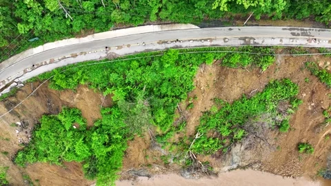 Drone view displays landslide damage alongside a cracked road. Stock Footage 310708000