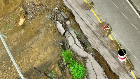 Drone view displays landslide damage alongside a cracked road. Stock Footage 310708016