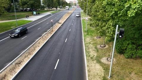 Drone view down a newly resurfaced divided avenue with a roadside speed camera Stock Footage 327491263