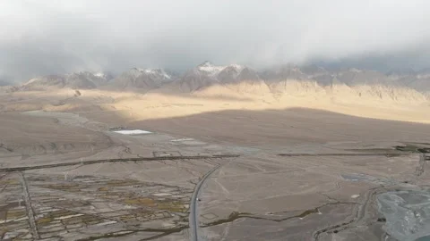 Drone view of dry mountain valley and distant snow peaks in Xinjiang China Stock Footage 337675026