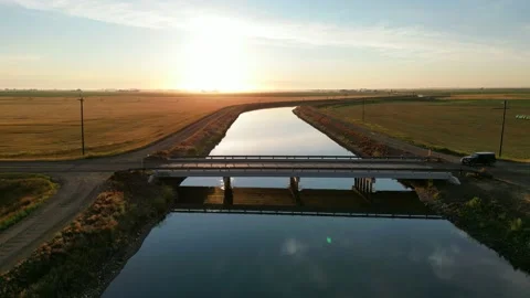 Drone view during sunrise over a farm hay field and river in Alberta Canada Stock Footage 228832019