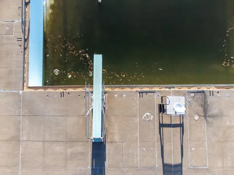 Drone view of an empty and drained winterized swimming pool above the diving Stock Photos