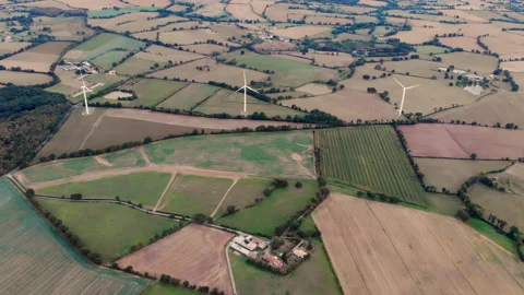 Drone view of Eolian farm renewable energy in fresh green field against clear Stock Footage 142033793
