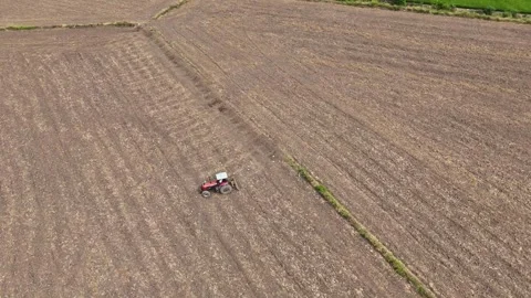 Drone view: Farming tractor preparing dry soil for crops Stock Footage 333713543