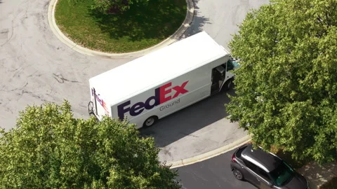 Drone view of Fedex white courier van delivering mail and parcels to their Stock Footage 248241499