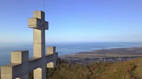 Drone view flies around stone or concrete cross high in mountains Video stock 166631690