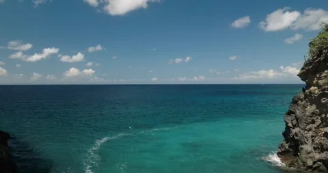 Drone view flying between rocks and cliffs over the ocean to the horizon Vidéo 275002977