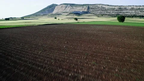 Drone view of flying low above fields with quarry hill on background. Stock Footage 154659040
