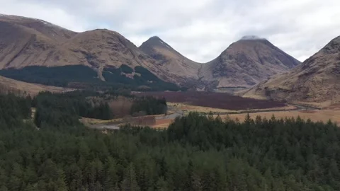 Drone view flying over a loch in the mountains of the Scottish Highlands Stock Footage 255499420
