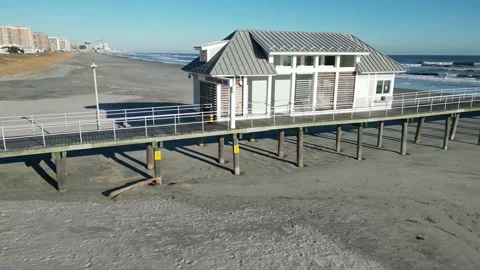 Drone view flying parallel to a wooden pier showing a person on the pier an.. Stock-Footage 225774662