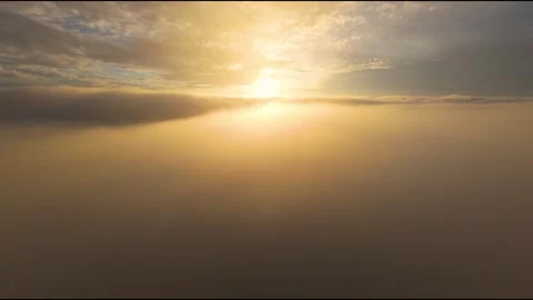 Drone View Flying Through Dense Cloud Layer Illuminated by Golden Sunset Light Stock Footage 319295291
