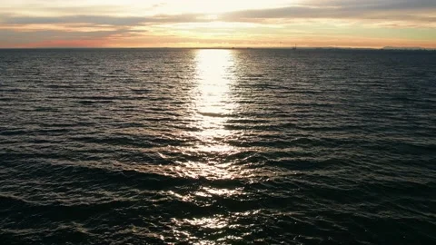 Drone view flying towards the sunset against the sea surface Stock Footage 209130327