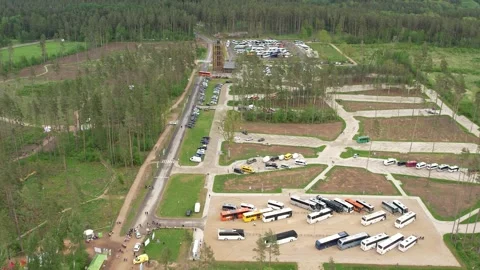 Drone view of a forest complex with parking areas, many buses, cars, roads, a Stock Footage 337245312