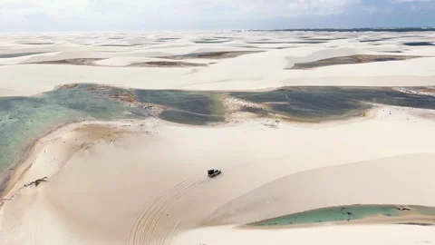 Drone View of Four-Wheel-Drive Tour Vehicle Crossing Lençóis Maranhenses Dunes Stock Footage 342443161