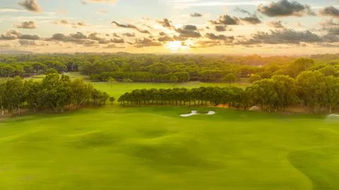 Drone view of golf course at sunset with beautiful sky. Concept of scenic beauty Stock Photos