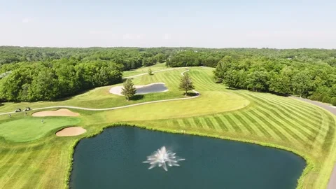 Drone view of a green golf course with grass cut lines and beautiful trees. Stock-Footage 310866548
