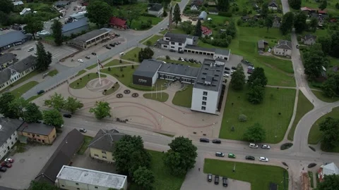 Drone view of a green small town with roads, residential buildings Видео 337245057