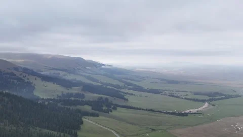 Drone view of green valley river and forests below cloudy mountains in Stock Footage 337884388