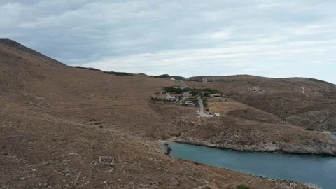 Drone view of hidden rocky cove with small coastal village at sunset Greece Stock Footage 344096562