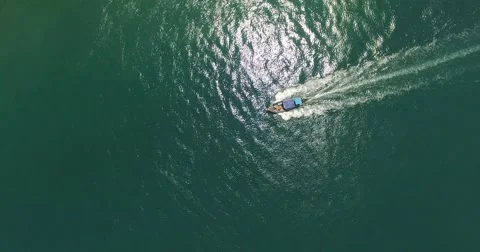 A drone view from high above of a boat passing in the green sea Stock Footage 64130041