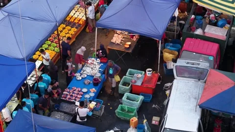 Drone view highlights Juru pasar malam with shoppers moving through narrow lanes 스톡 동영상 332093225