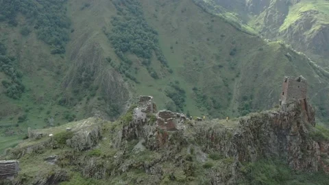 Drone view of historical castle Mutso with travellers at the top of mountains Video stock 237773623