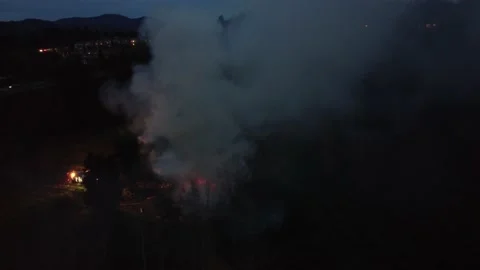 Drone view of a house on fire at night. Firefighter on-site to extinguish. 動画素材 194150212