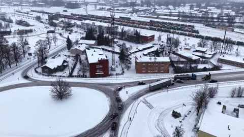 Drone view of a jackknifed semi trailer on an icy curved intersection in a Stock Footage 332044679