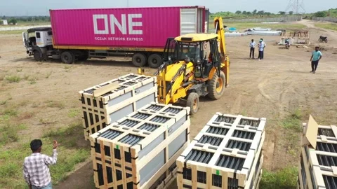 Drone view of JCB putting solar power crate in array Stock Footage 314704296