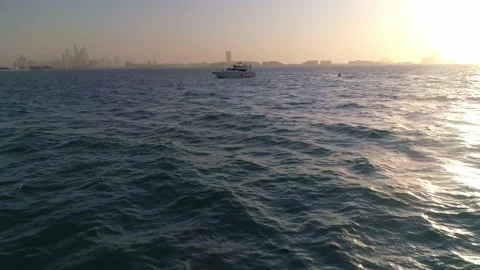 Drone view of Jet ski having fun with luxury yacht in open sea and sun set Video stock 141786062