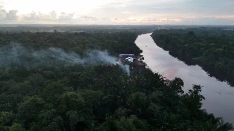 Drone View of Kapuas River Through Dense Forest with Smoke from Settlements Stock Footage 334211386
