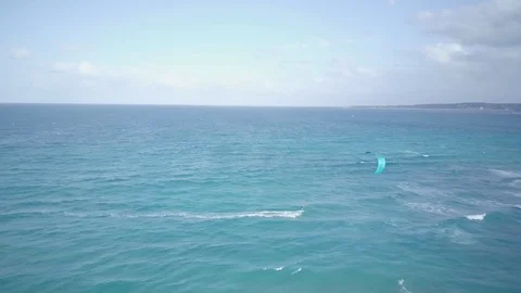 Drone view of a kite boarder is pulled across water by a power kite Stock Footage 122396792