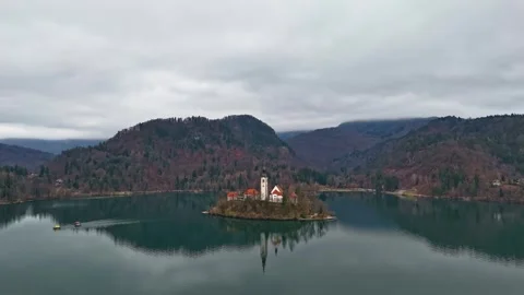 Drone view of Lake Bled's island church amid calm winter water and hills Stock Footage 336467622
