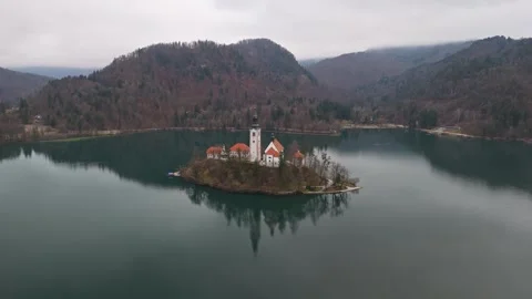 A drone view of Lake Bled's island church amid winter waters and mountains Stock Footage 336467741