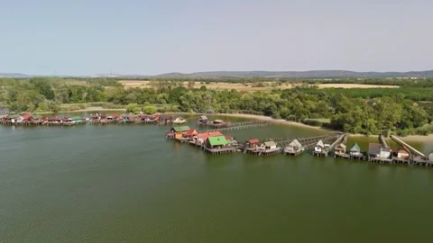 Drone view of Lake Bokod floating village with huts and wooden piers below Video stock 345610620