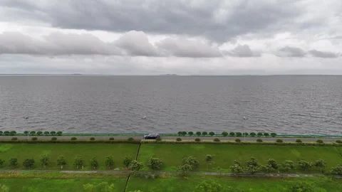 Drone view of lakeside road and green waterfront parkland in China Stock Footage 337885544