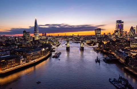 Drone view of the landmark Tower Bridge with illuminated lights over ocean Stock Photos