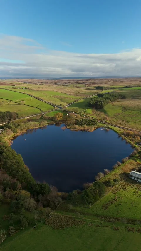 Drone view Langley Dam Reservoir Northumberland fields, roads and fishing boats Video stock 327725438