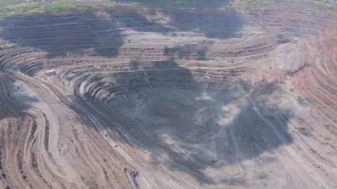 Drone view of large open quarry with terraced levels and mining vehicles Stock Footage 315630173