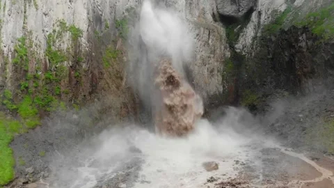 Drone view of large, powerful waterfall with brown water erupts from the rocks Video stock 339364780